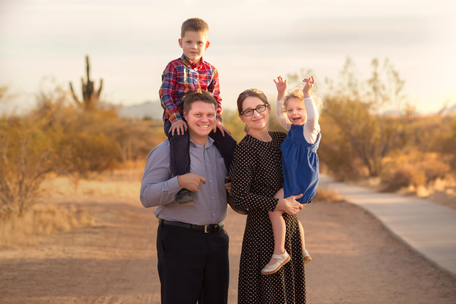 Posed but Candid family photo of family of four in a desert hiking trail in Phoenix Arizona